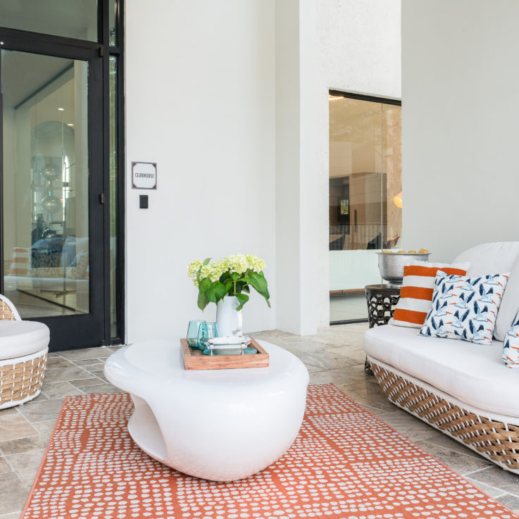 Wicker furniture with white cushions outside of the clubhouse