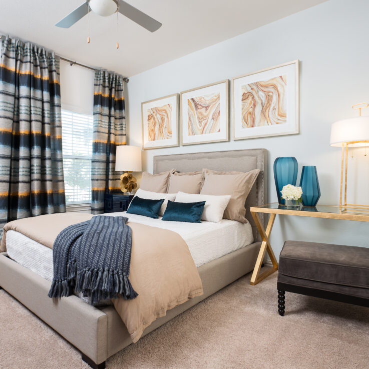 Bedroom with white and beige sheets and pillows and a window